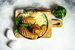 Baked potato, spinach and cabbage salad on concrete counter with copy space