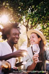 A man and woman smiling drinking wine outside o5oqkb