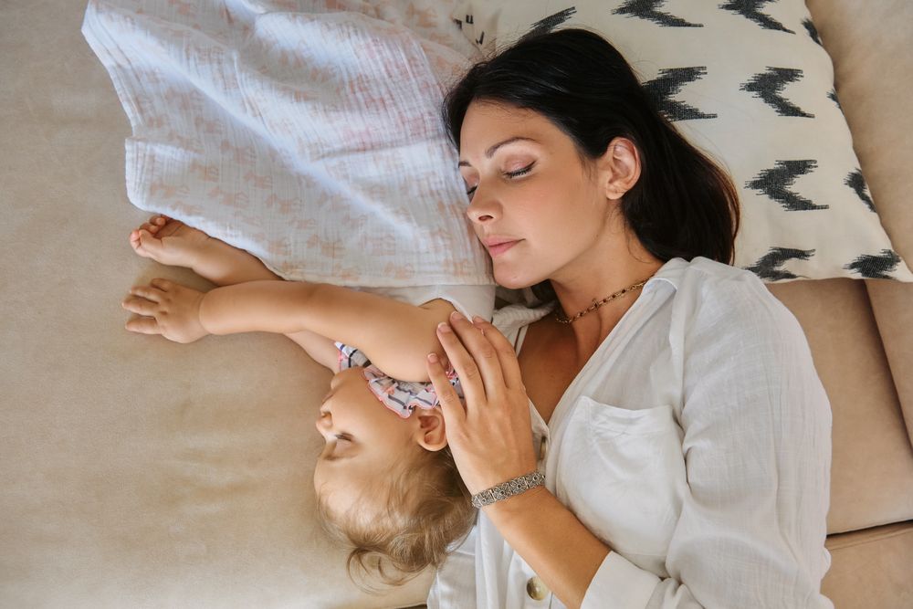 Aerial photo of a mother and toddler sleeping together on the so