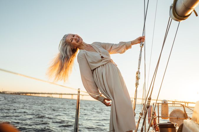 Smiling woman with gray hair leaning over side of a boat