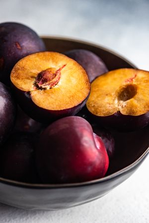 Bowl of fresh ripe plums on kitchen counter