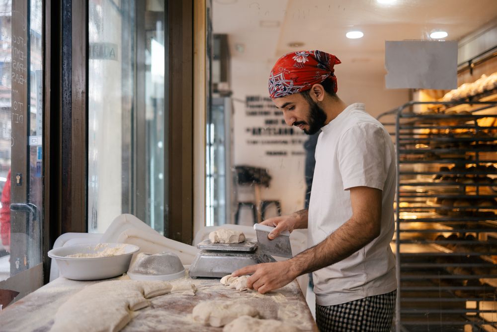 Arabic baker cutting dough with scapula