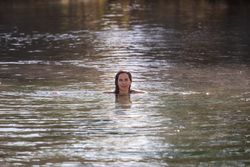 Woman swimming and looking at camera in lake