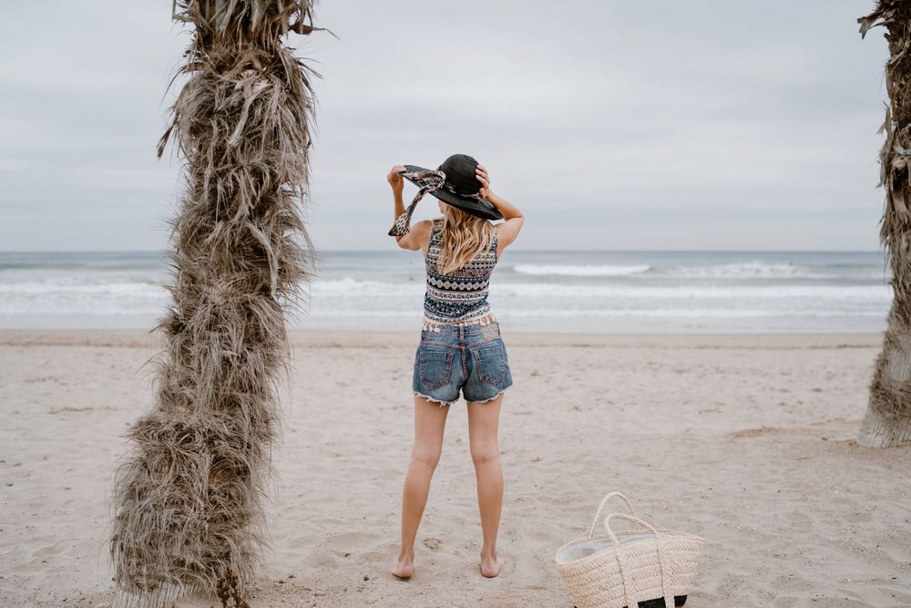 Young female relaxing on beach with hat