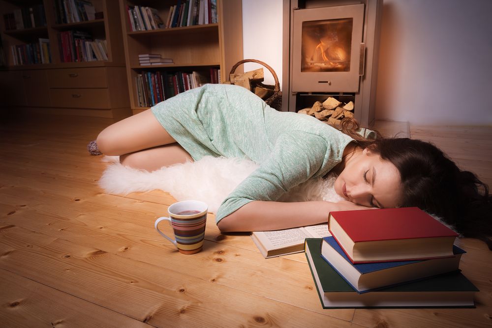 Woman sleeping in front of fireplace