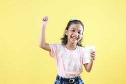 Asian Little Girl Kid Smile Holding Milk Glass and Show Power Strong Gesture