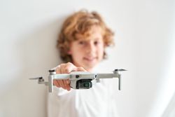Adorable preteen boy demonstrating drone to camera