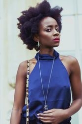 Young woman in blue tank top wearing silver necklace