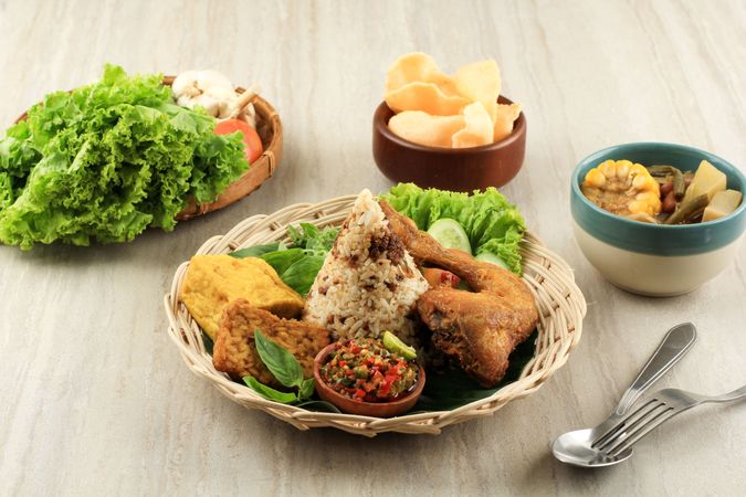 Indonesian chicken dish served with rice, salad and spicy sauce
