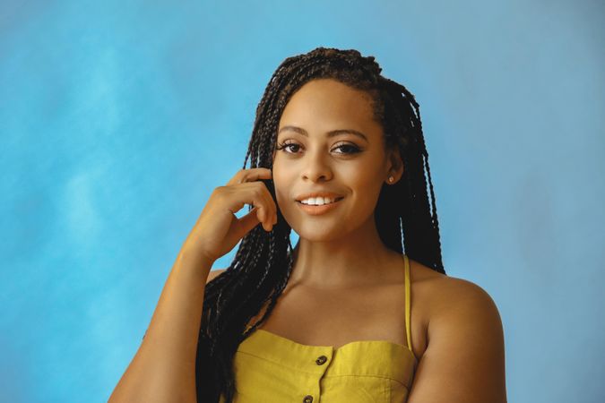 Portrait of curious female with long braided hair in yellow clothes