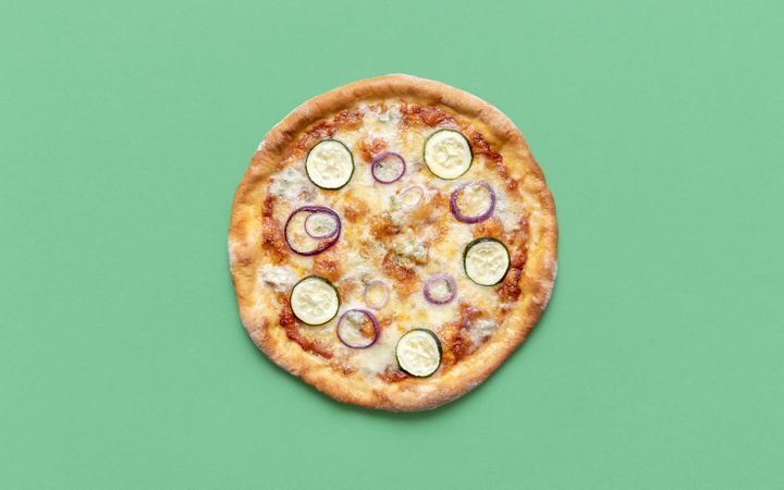 Homemade vegetarian pizza isolated on a green background