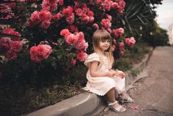 Blonde girl sitting beside pink floral tree