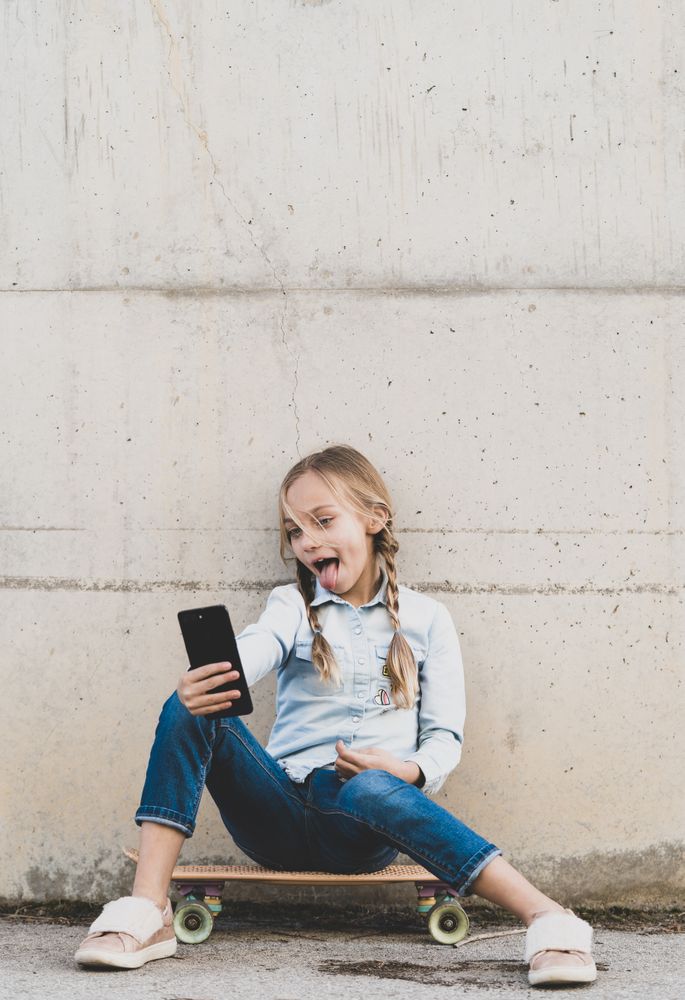 Kid using mobile phone with skate