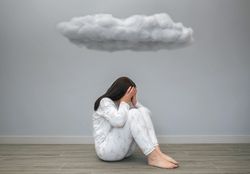 Woman covering her face with hands under a dark cloud