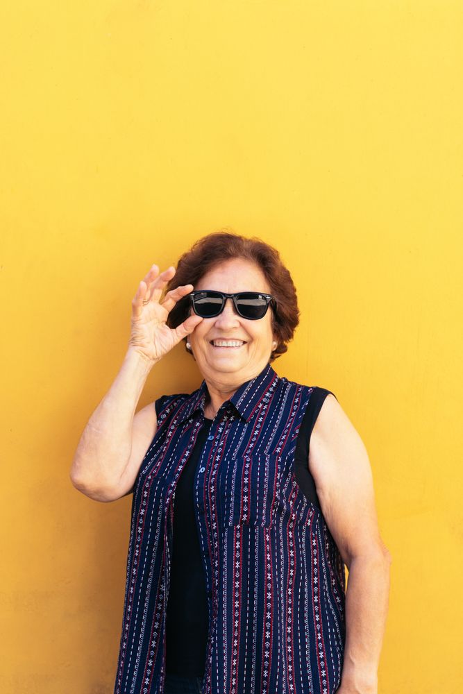 Stylish older woman in sunglasses and colorful clothes