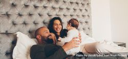 Happy parents playing with their newborn son on bed at home 5Q3nnb
