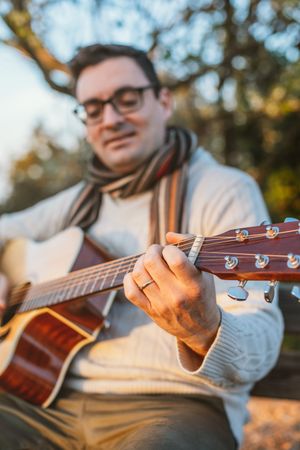 Man playing the guitar on the outside