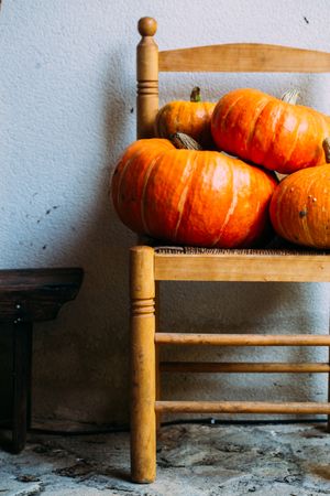 Shiny orange pumpkins composed on chairs