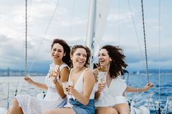 Cheerful friend with wine having fun on yacht