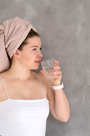 Drinking water during skincare routine.