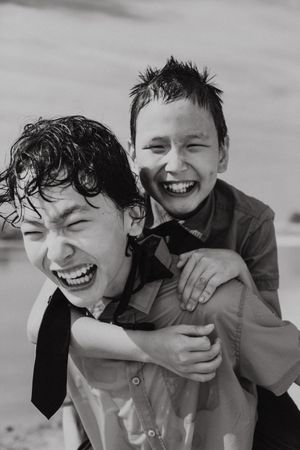 Happy boy in piggyback ride over back of brother