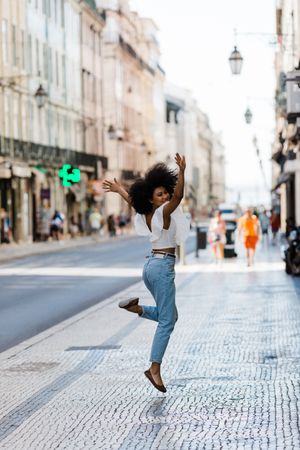 Black female jumping on urban background