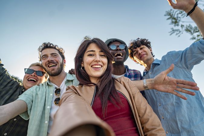 Group of happy multiethnic friends taking a selfie outdoors.