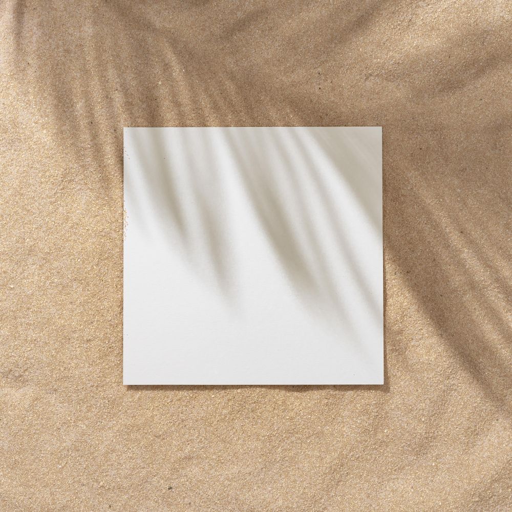 Sand with palm leaf shadows and central square