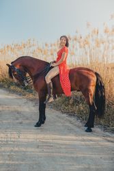 Cheerful woman riding horse in countryside