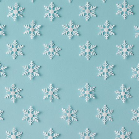 Winter pattern made of uniform snowflakes on blue background