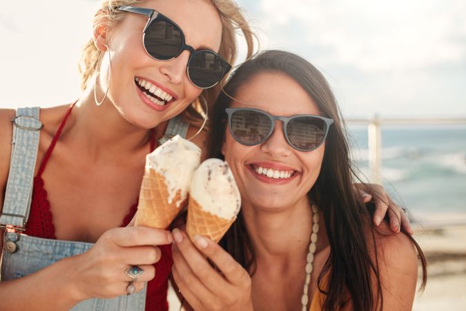 Shot of two young friends enjoying ice cream together on a summer day outdoors