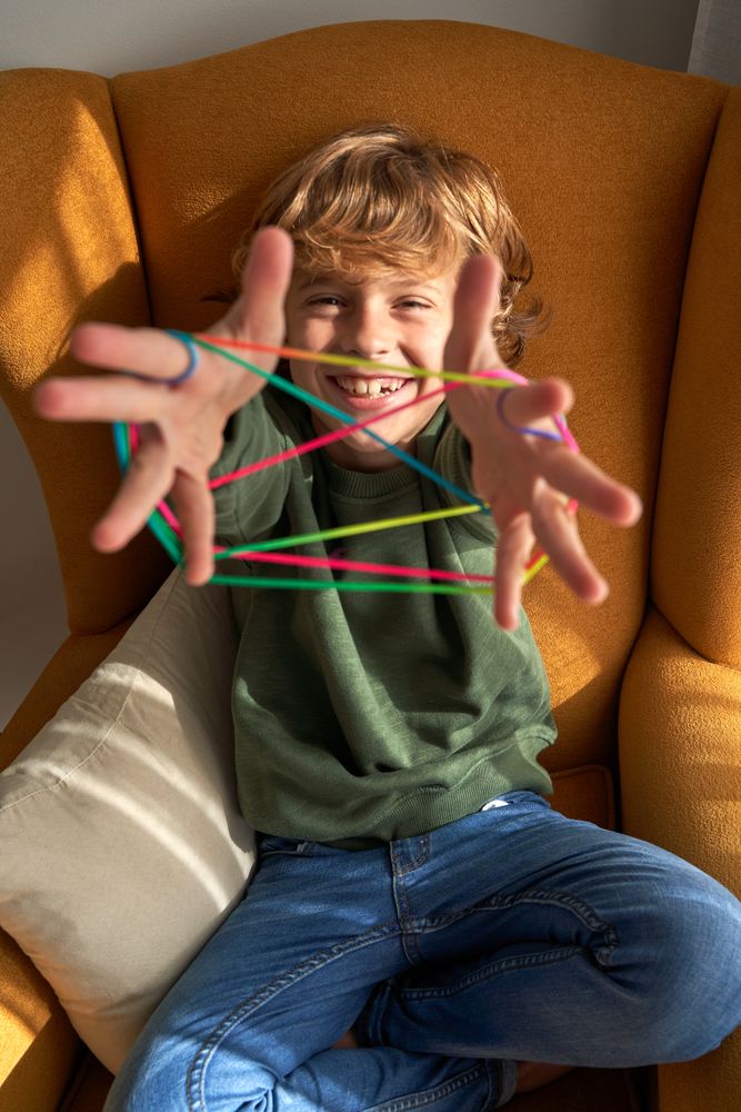 Happy kid enjoying string game at home