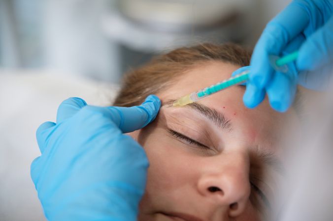 Woman receiving facial injection during rejuvenation treatment in clinic