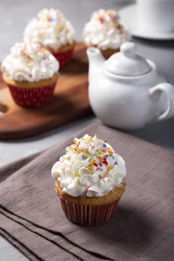 Tasty party cupcakes on the table. Cupcakes with whipped cream.
