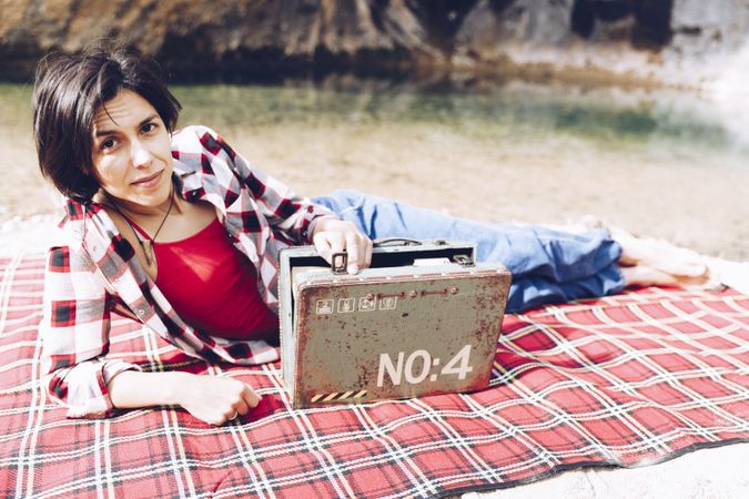 Cheerful woman with old case on picnic