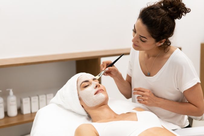 Female having a face mask professionally applied by beautician