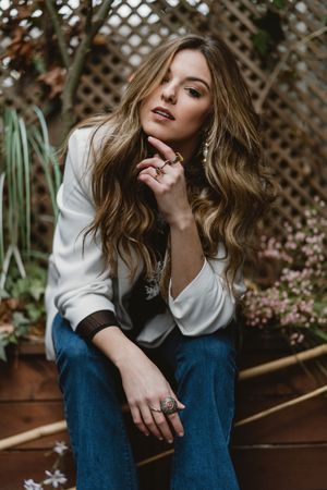 Woman sitting on planter in garden