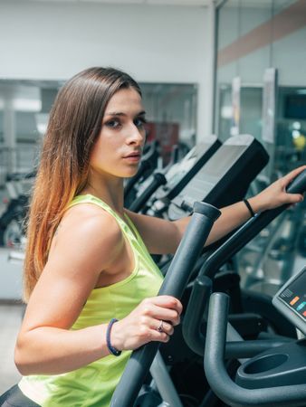 Young woman exercising on modern machine
