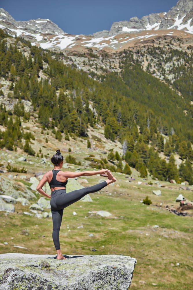 Young female balanced on one leg doing extended hand to toe pose