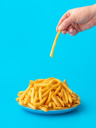 French fries plate isolated on a blue background