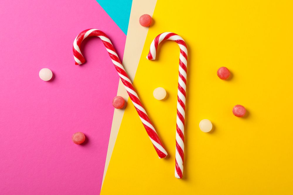 Composition with sweet candies on multicolored background, space for text