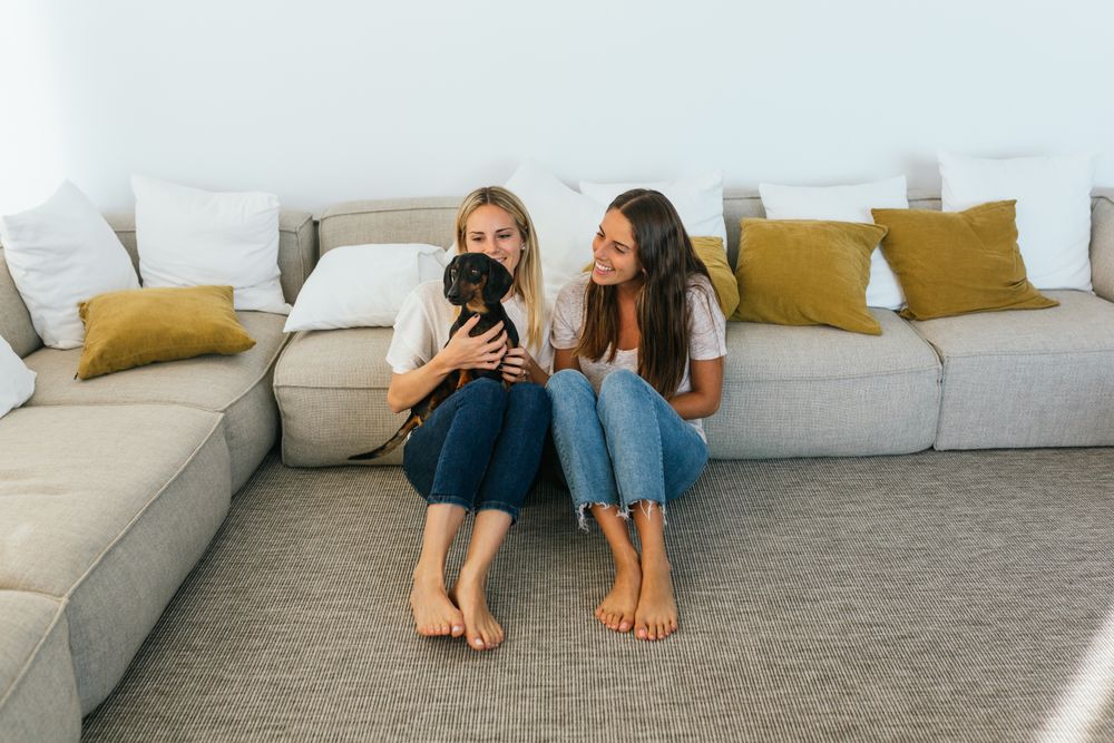 Smiling girlfriends with cute dog