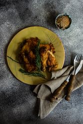 Top view plate of grilled chicken with rosemary with cutlery