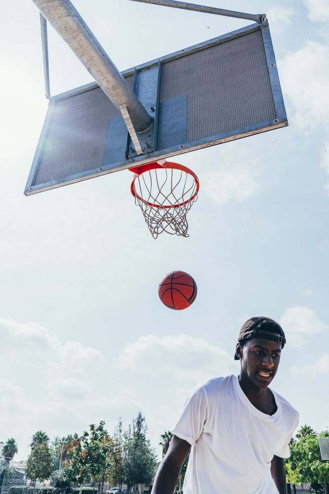 Black sportsman after scoring in basketball court