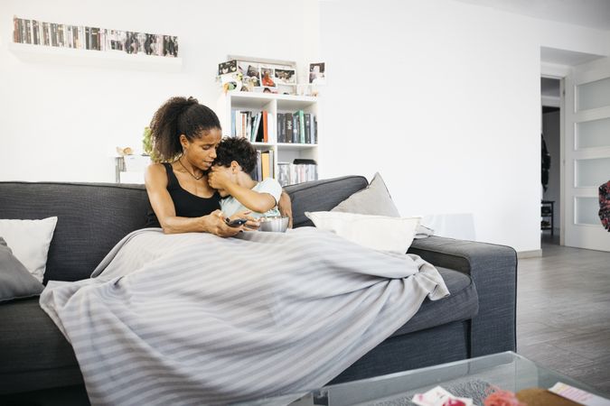 Mother and daughter watching tv at home