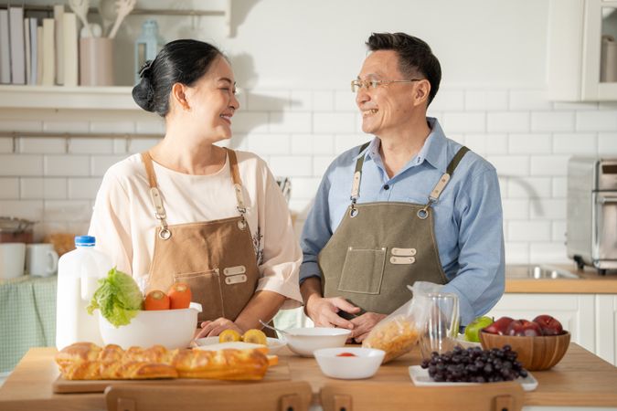 Asian older couple cooking breakfast in the kitchen.