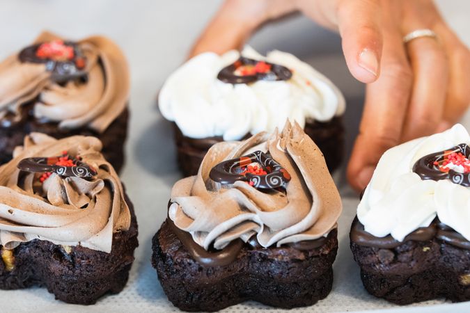 Crop baker holding vegan dessert in kitchen