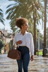 Stylish Black woman walking on street