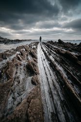 Anonymous person on rough stone shore