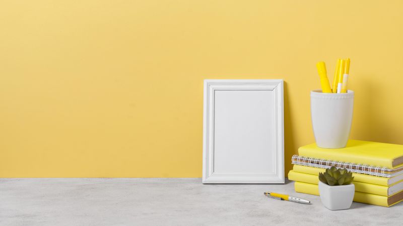 Yellow books and blank frame with copy space